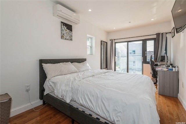 bedroom featuring access to exterior, dark hardwood / wood-style floors, and a wall mounted air conditioner