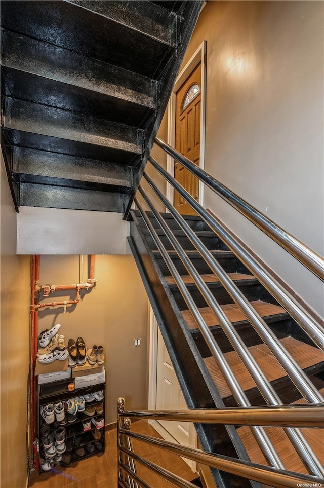 stairway featuring parquet flooring