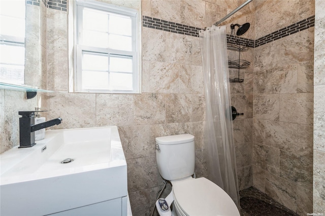 bathroom featuring vanity, curtained shower, toilet, and tile walls