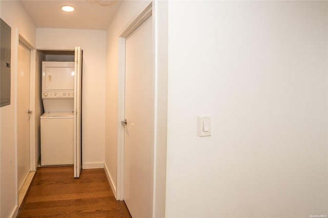 hallway featuring dark hardwood / wood-style flooring and stacked washer and dryer