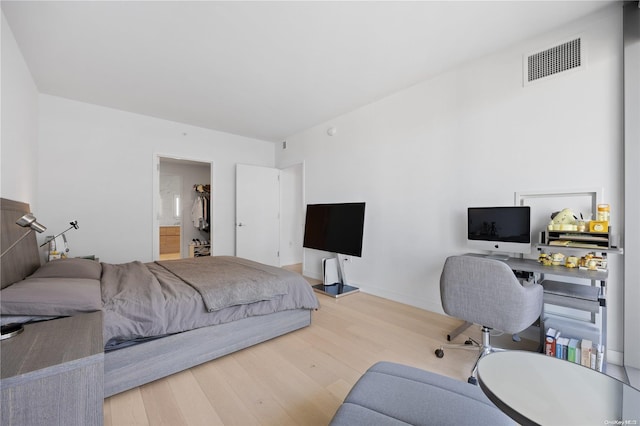 bedroom with hardwood / wood-style flooring and a spacious closet