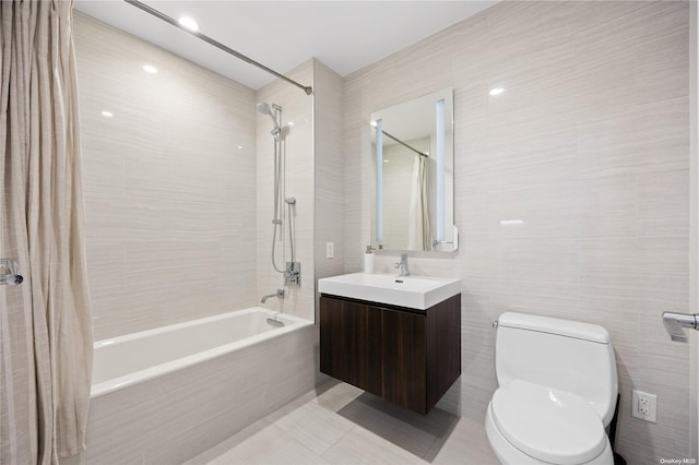 full bathroom featuring tile patterned flooring, tile walls, toilet, vanity, and shower / tub combo