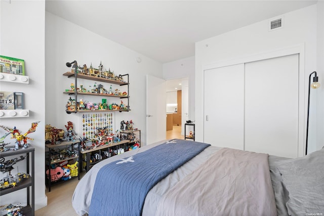 bedroom with light colored carpet and a closet