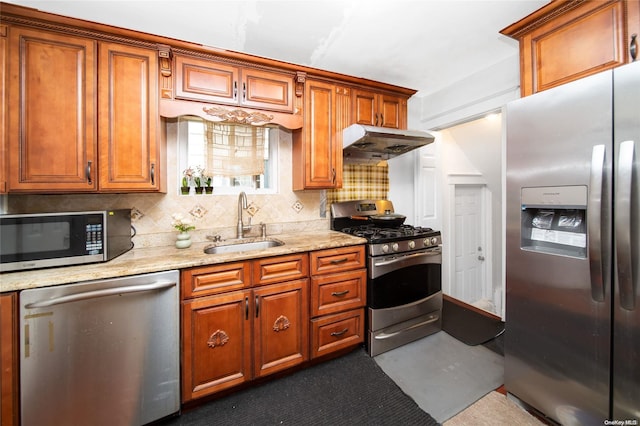 kitchen with light stone counters, sink, stainless steel appliances, and tasteful backsplash