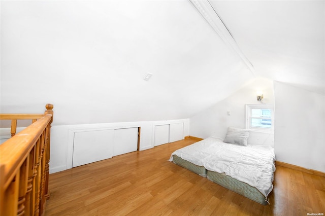 bedroom featuring wood-type flooring and lofted ceiling