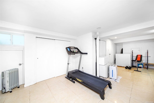 exercise room with radiator heating unit and light tile patterned floors