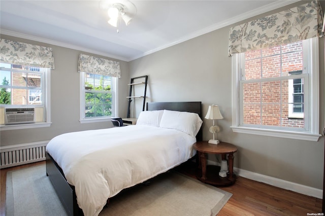 bedroom featuring radiator, ceiling fan, crown molding, hardwood / wood-style floors, and cooling unit