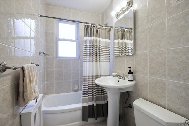 full bathroom featuring sink, shower / bath combo, toilet, and tile walls