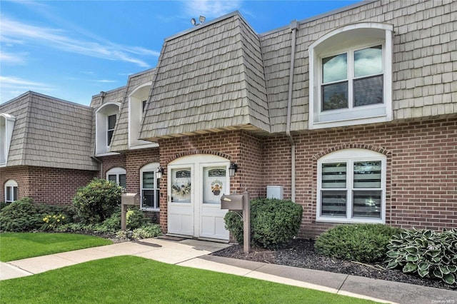 entrance to property featuring a lawn