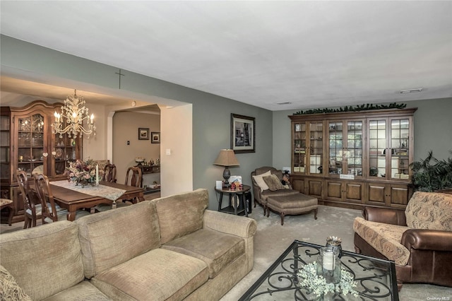 carpeted living room with a notable chandelier