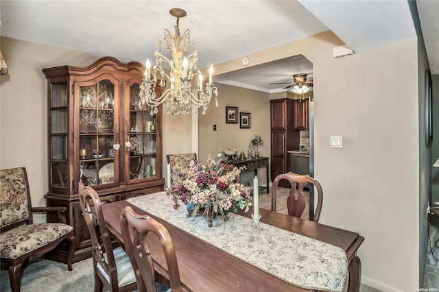 dining area with ceiling fan, light colored carpet, and crown molding