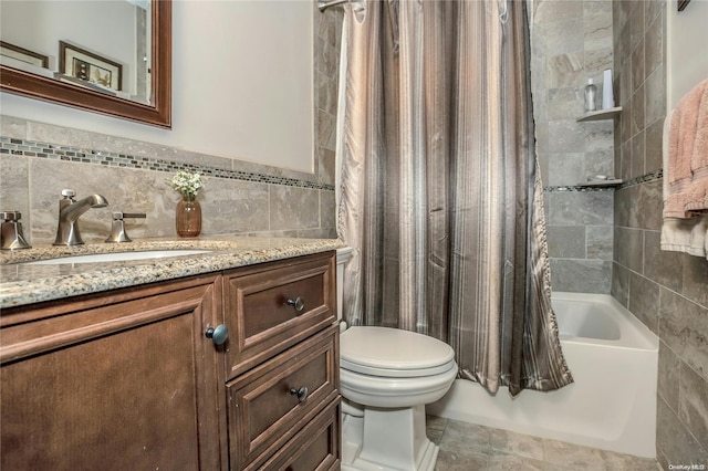 full bathroom with toilet, vanity, tile walls, and shower / bath combo with shower curtain