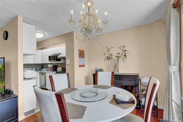 dining space with light hardwood / wood-style flooring and a notable chandelier