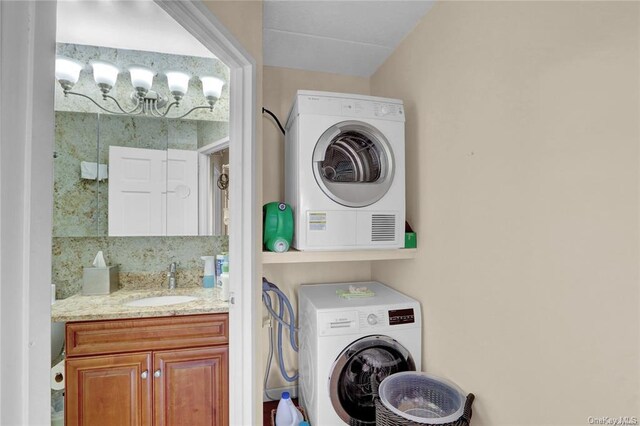 washroom with stacked washer / dryer and sink