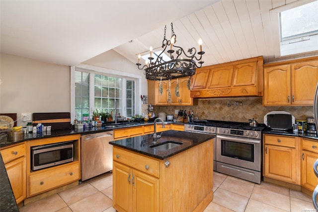 kitchen featuring custom exhaust hood, a kitchen island with sink, sink, hanging light fixtures, and appliances with stainless steel finishes