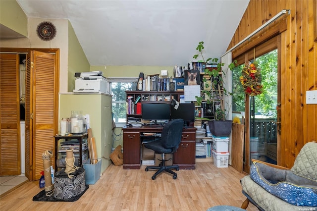 office with wooden walls, light hardwood / wood-style floors, and vaulted ceiling