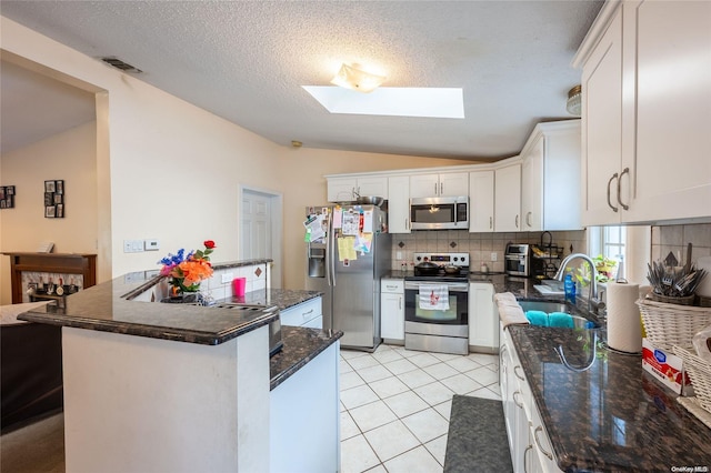49 Concord Rd, Shirley, NY 11967 - kitchen with stainless steel appliances, vaulted ceiling, a sink, backsplash, and a skylight