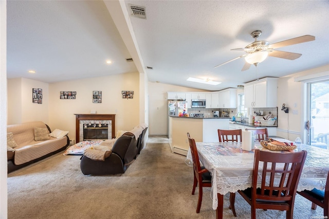 49 Concord Rd, Shirley, NY 11967 - dining space with lofted ceiling, ceiling fan, light carpet, baseboard heating, and a glass covered fireplace