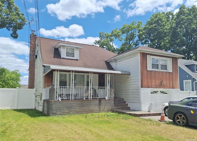 view of front of property with a garage, covered porch, and a front yard