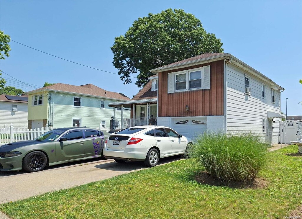 102 Hausch Blvd, Roosevelt, NY 11575 - view of front of house with an attached garage and driveway