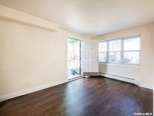 unfurnished room featuring dark hardwood / wood-style flooring, a healthy amount of sunlight, and a baseboard heating unit