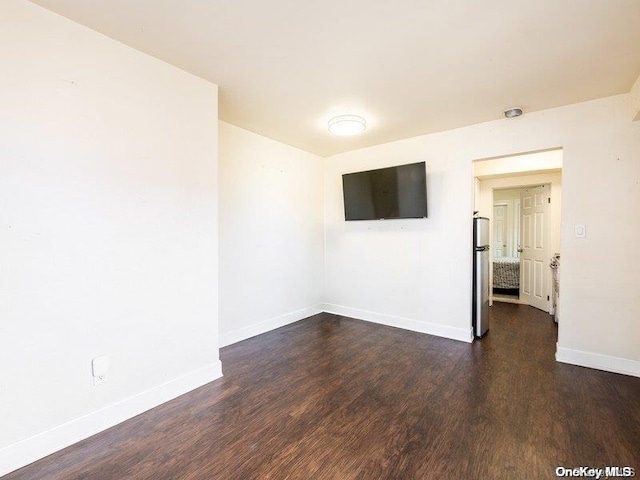 unfurnished room with dark wood-type flooring