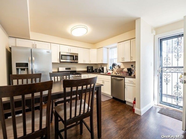 kitchen featuring white cabinets, appliances with stainless steel finishes, and dark hardwood / wood-style floors