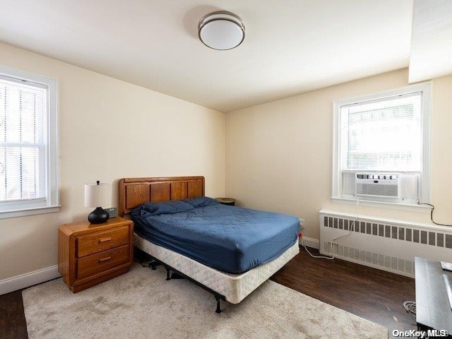 bedroom featuring hardwood / wood-style floors, radiator, and cooling unit