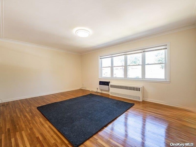 interior space featuring radiator, wood-type flooring, and ornamental molding