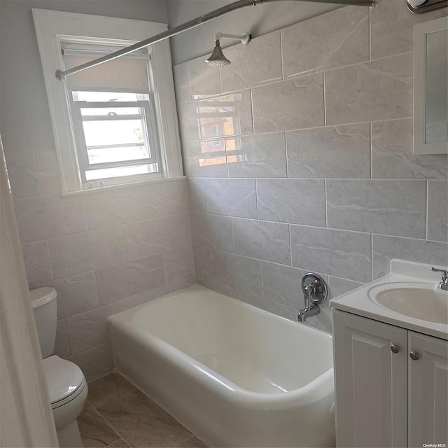 full bathroom with shower / bathing tub combination, vanity, toilet, and tile walls