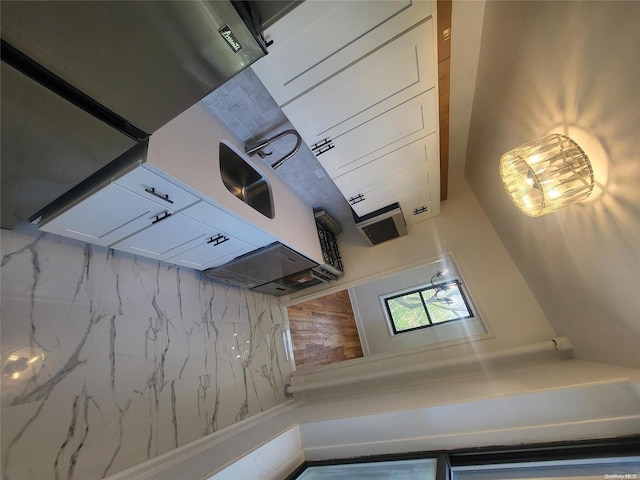 kitchen featuring tasteful backsplash and white cabinetry