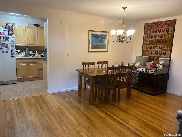 dining room with light hardwood / wood-style flooring and a chandelier