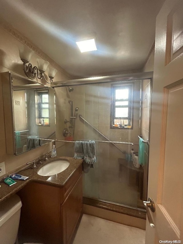 bathroom featuring vanity, toilet, and walk in shower