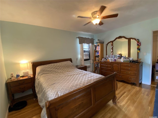 bedroom featuring radiator, light hardwood / wood-style flooring, and ceiling fan