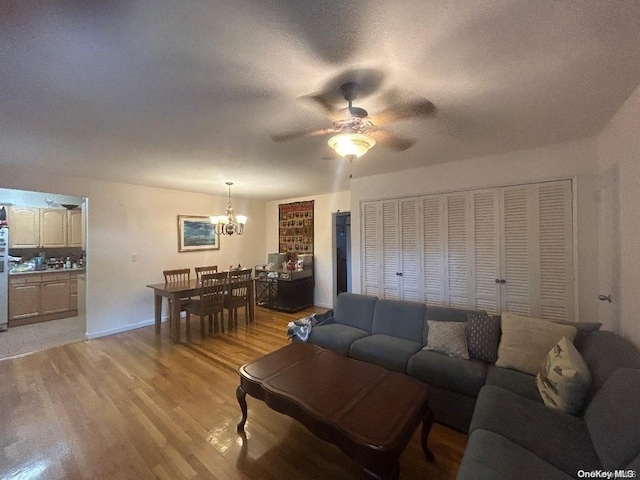 living room with light hardwood / wood-style flooring and ceiling fan with notable chandelier