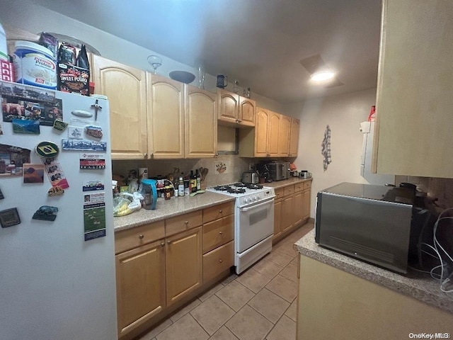 kitchen featuring decorative backsplash, light brown cabinetry, white appliances, and light tile patterned floors