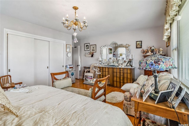 bedroom with light hardwood / wood-style floors, a closet, and a notable chandelier