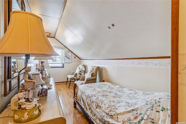 bedroom with lofted ceiling and light wood-type flooring