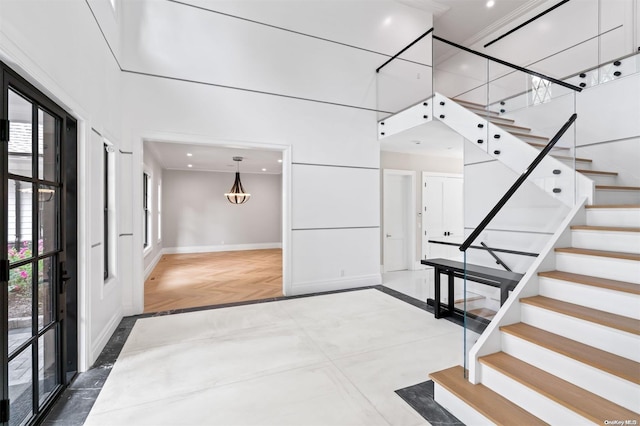 entrance foyer with a towering ceiling and parquet flooring