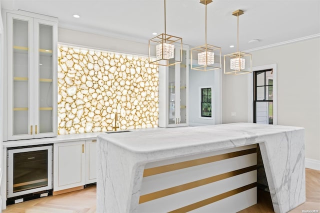 interior space with pendant lighting, light parquet floors, white cabinets, crown molding, and wine cooler