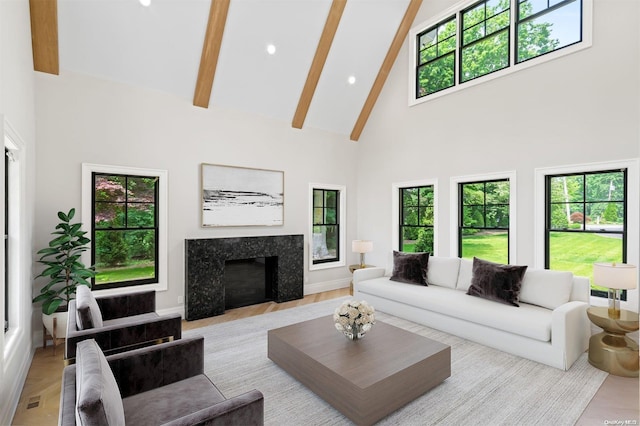 living room featuring a premium fireplace, beamed ceiling, high vaulted ceiling, and light hardwood / wood-style flooring