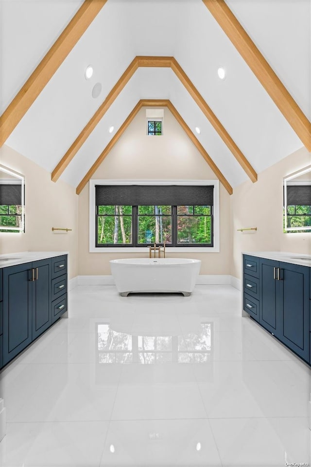 bathroom with lofted ceiling with beams, plenty of natural light, and a tub to relax in