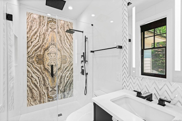 bathroom featuring decorative backsplash, vanity, and a shower with shower door