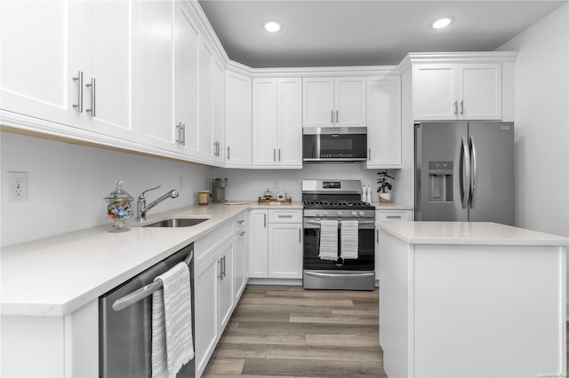 kitchen featuring white cabinetry, sink, stainless steel appliances, and light wood-type flooring