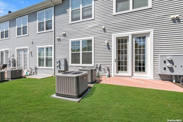 back of property with a yard and central AC unit