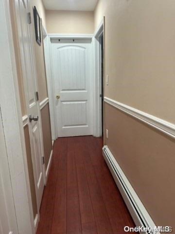 hallway with dark hardwood / wood-style flooring and a baseboard radiator