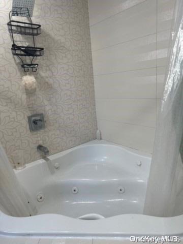 bathroom with shower / bath combo with shower curtain