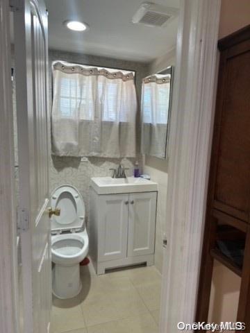 bathroom with tile patterned floors, vanity, and toilet