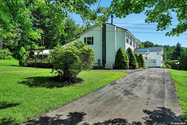 view of side of property with a lawn and a garage