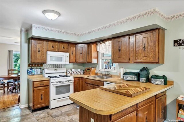 765 Sheep Pen Rd, Call Listing Agent, NY 13849 - kitchen with white appliances, a sink, light countertops, brown cabinetry, and a peninsula